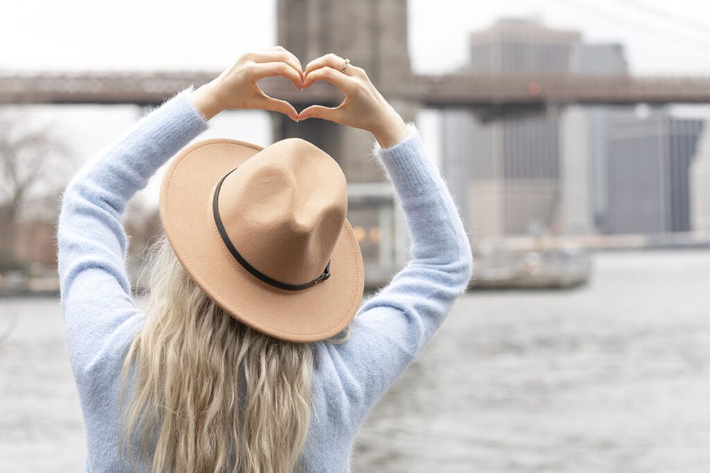 For your future self 8 - Woman making hand hearts in front of scenic bridge